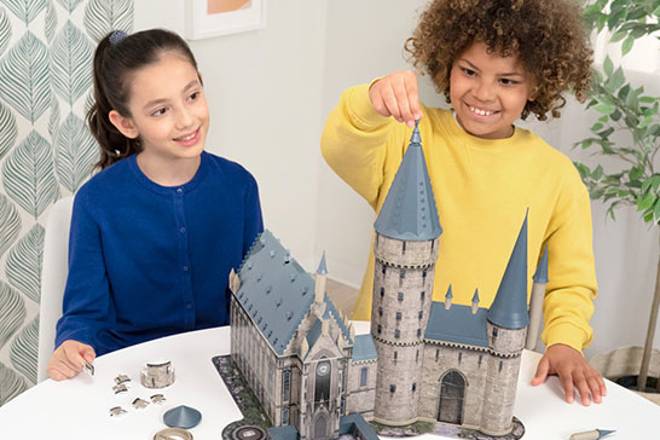 Fille et garçon avec un puzzle 3D Ravensburger Château de Poudlard